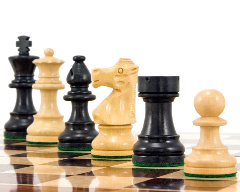 French Knight Series Ebonised Staunton chess pieces on a chessboard, showcasing expertly turned boxwood chessmen, 3.25 inch king.