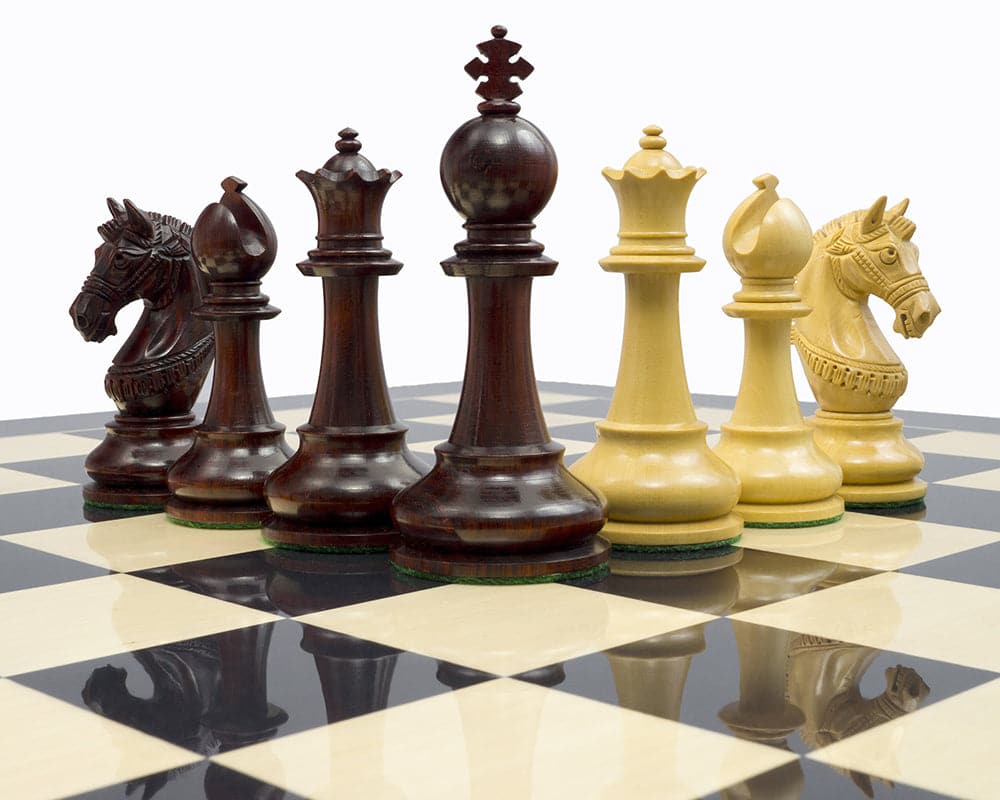 The La Valletta Redwood Chessmen on a chessboard, featuring detailed knights and a 4.5 inch king, ideal for a 21 inch board.