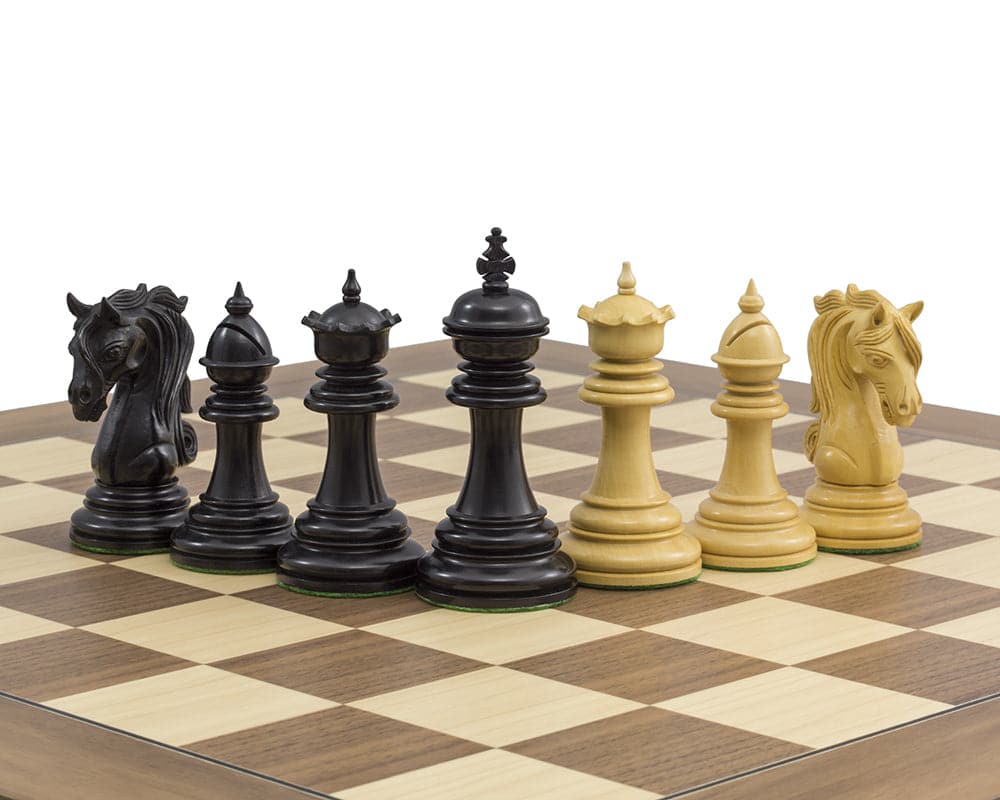 The Kingsgate Ebony Chessmen on a chessboard, featuring intricate ebony and boxwood pieces with a 4.25 inch King and ornate knights.