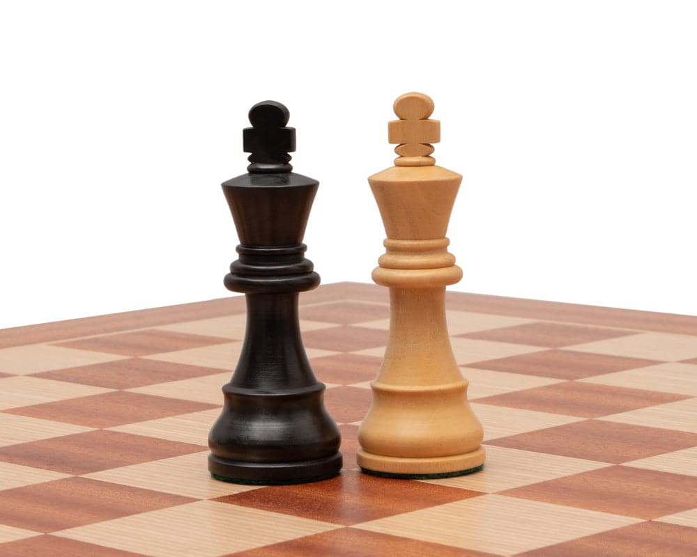 Black and natural wooden chess kings on a high-quality Mahogany and Birch chessboard from Manopoulos, featuring 2-inch playing squares.