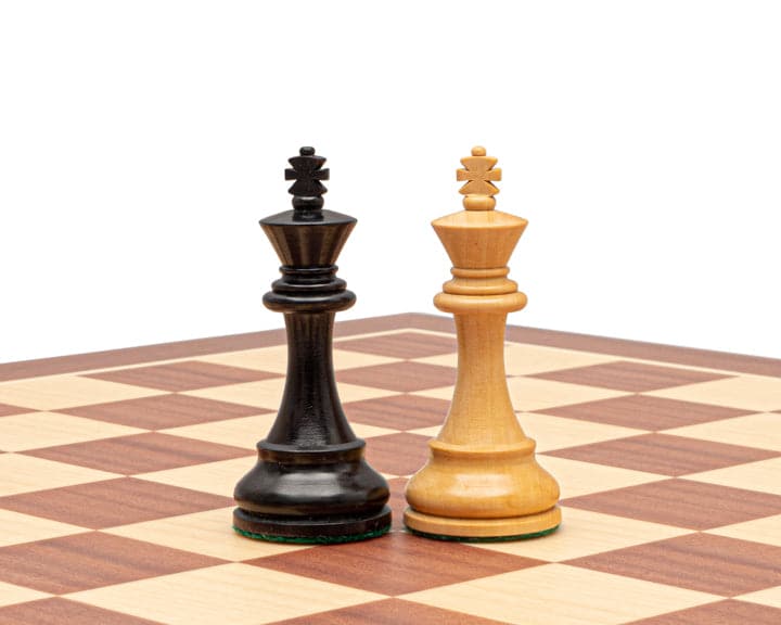 British ebonised chess king and natural boxwood chess king on a chessboard in Staunton design