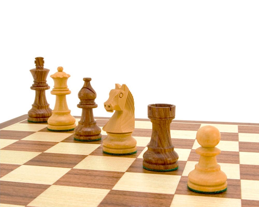 Down Head Knight Academy small chess set with Ebonized Chessmen on a walnut board displaying Staunton chess pieces and 2.5-inch king.